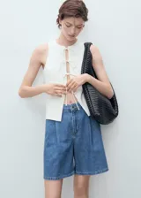 Short de denim azul de tiro medio, con bolsillos laterales, bolsillos traseros, trabillas para cinturón y detalle de pinzas delanteras.