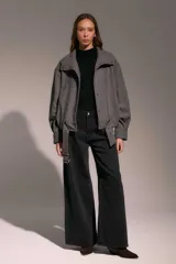 Campera bomber de paño gris con cuello alto, cierre frontal con botones a presión y cinturón integrado en el ruedo.