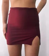 Minifalda negra de crepe, tiro alto, corte ajustado y tajo lateral.