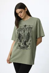 Remera de algodón de manga corta y cuello redondo, con diseño holgado y estampado frontal con motivos florales y texto.