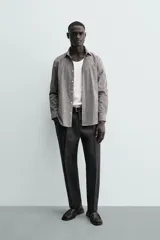 Camisa de corte regular fit confeccionada en algodón, con diseño de rayas verticales finas, cuello italiano, manga larga con puños abotonados y cierre frontal de botones.