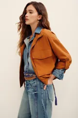 Campera tostado de estilo utilitario, con cuello alto, cierre frontal y bolsillos frontales con solapa. Presenta mangas largas con presillas.
