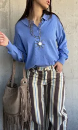 Sweater de punto celeste con cuello polo, cierre frontal parcial con botones y textura geométrica tipo rombos.