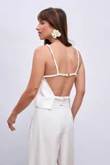 Blusa blanca sin mangas con tirantes finos y escote cuadrado.