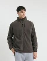 Campera de micropolar color verde oscuro, con cuello alto, cierre frontal completo, bolsillos laterales y un bolsillo con cierre en el pecho.