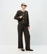 Pantalón de corte recto con estampado a cuadros, confeccionado en mezcla de fibras. Presenta cintura con presillas, bolsillos laterales y traseros, y aletas decorativas en el frente.