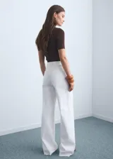 Jeans blancos de tiro alto con diseño acampanado y bajo deshilachado, con cierre de cremallera y botón, trabillas para cinturón y bolsillos traseros.