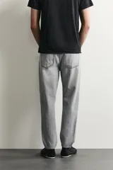 Jeans de corte slim cropped confeccionados en denim de algodón rígido con efecto lavado. Presentan tiro medio, cierre frontal con cremallera y botón, y diseño clásico de cinco bolsillos.