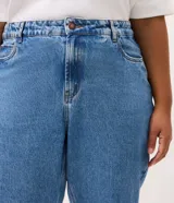 Pantalón mom jeans de tiro alto con lavado efecto mármol, corte holgado en cadera y piernas con ruedo ajustado. Cuenta con trabillas en la cintura, bolsillos funcionales y cierre frontal con botón.
