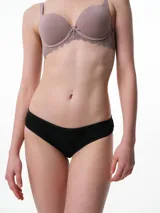 Bombacha tipo bikini de algodón acanalado en color negro, con detalles de puntilla en los laterales y tiro medio.