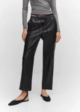 Pantalón de cuero sintético negro, de corte recto, largo y tiro medio. Presenta cintura elástica con cordón ajustable y bolsillos laterales.