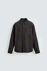 Sobrecamisa de corte relajado confeccionada en tejido de algodón con textura. Presenta cuello solapa, cierre frontal con botones, manga larga con puños abotonados y un bolsillo plastrón en el pecho.
