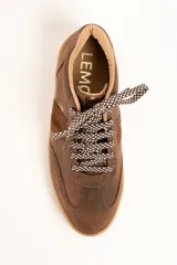 Zapatillas urbanas de cuero color marrón, con cordones estampados en tonos marrones y blancos, y suela de goma al tono. Presentan una franja lateral de gamuza y detalles con la marca en dorado.