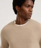 Suéter negro de tejido de punto maquinetado con cuello redondo y manga larga.