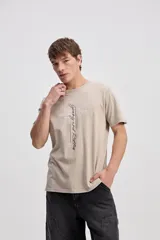 Remera de algodón color azul con efecto desgastado, de manga corta y corte recto, con estampa frontal tipográfica.