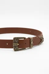 Cinturón de cuero negro con hebilla y pasador metálicos plateados de diseño estilo western con grabados ornamentales.