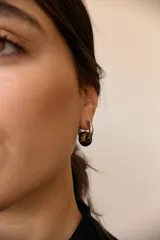 Aros de argolla en acero quirúrgico con dije de piedra natural en tono azul.