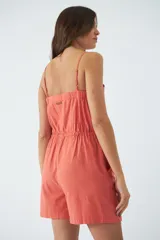 Monoprenda corta de color verde oliva, con tirantes finos ajustables, cierre frontal con botones y cintura elástica con cordón ajustable. Cuenta con bolsillos laterales.