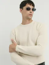 Sweater de punto con textura tipo waffle, color negro, de corte clásico con cuello redondo y mangas largas.