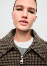 Chaqueta bomber de mezcla de lana con diseño de pata de gallo en tonos marrones y verdes, cuello camisero, manga larga con puños elásticos y bajo elástico. Cuenta con forro interior y cierre delantero con cremallera.