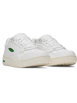 Championes Under Armour modelo W Flex, de color blanco con detalles en verde. Presentan un diseño de corte bajo con empeine de cuero premium, panel de talón acanalado y suela de goma resistente.