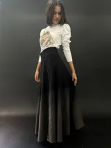Falda larga de lana color negro con teñido degradado en tonos grises. Corte a la cintura con bolsillos laterales y cierre invisible.