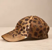 Gorro con visera de cuero con estampa animal print de leopardo, ojalillos metálicos de ventilación y diseño estructurado.