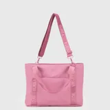 Tote bag de diseño funcional en color rosado, confeccionada en material resistente al agua. Cuenta con doble asa de mano y correa ajustable extraíble con el logo de la marca estampado. Incluye compartimento interno para laptop de hasta 15 pulgadas y bolsillo trasero adaptable para enganchar a maletas.
