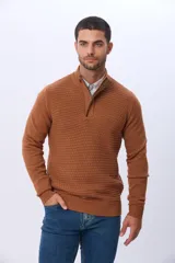 Buzo de punto color beige, con cuello alto y cierre frontal con cremallera y solapa de gamuza con botón. Presenta un tejido texturizado en el cuerpo y mangas lisas.