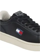 Zapatillas de tenis Tommy Jeans de corte bajo, confeccionadas en piel napa negra. Presentan cordones al tono, suela de goma color crema, panel a contraste en el talón y parche distintivo de la marca en el lateral.