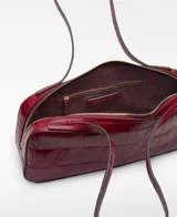 Bolso tipo bowling Mica de piel bovina, color rojo oscuro, con grabado efecto cocodrilo. Presenta un compartimento principal con cierre de cremallera, bolsillo interior con cierre y asas de hombro.