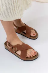 Sandalias de cuero marrón con tiras cruzadas, base de corcho y suela antideslizante.