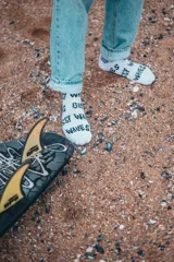 Pack de dos pares de medias blancas con texto 'Glassy Waves' estampado en negro.