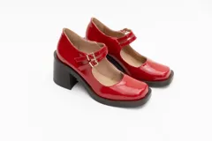 Guillerminas de cuero charol negro con punta cuadrada, taco ancho y correa sobre el empeine con doble hebilla dorada.