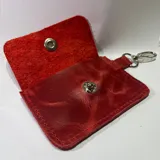 Tarjetero pequeño de cuero rojo con cierre metálico plateado y llavero.