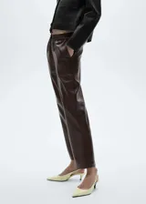 Pantalon tipo jogger de cuero sintético color marrón oscuro, con cintura elástica y cordón ajustable. Presenta un corte recto y diseño crop.