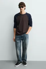 Zapatilla de cordones color negro con parte superior lisa, horma redonda y forro interior a contraste. Suela de goma color crema con ligera textura y detalle en el talón color crema.