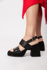 Sandalias negras de cuero con plataforma delantera de 3 cm y taco de 9 cm forrado. Tiene doble tira y ajuste con hebilla.