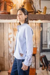 Camisa de manga larga con rayas finas, cuello mao con volados y cierre frontal de botones.
