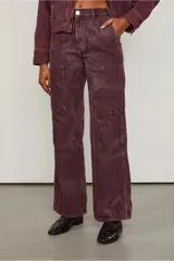 Pantalón de tiro medio color borgoña, con dos parches delanteros que simulan ser bolsillos y costuras visibles.