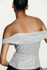 Top de tejido mesh con aplicación de strass, diseño de hombros descubiertos y escote drapeado. Presenta un corte ajustado y cierre lateral con cremallera oculta.