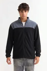 Campera de polar con cierre frontal completo, cuello alto y diseño bicolor en gris y negro. Cuenta con bolsillos laterales y puños elásticos.