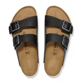 Sandalias Birkenstock modelo Arizona con doble tira ajustable de cuero negro y hebillas metálicas. Presenta plantilla anatómica de corcho y suela de goma antideslizante.