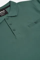 Polo verde con cuello clásico, tapeta de tres botones, bolsillo de parche en el pecho y calce regular.