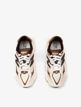 Championes New Balance modelo 9060, de diseño chunky en tonos beige y marrón con detalles en blanco, capellada de malla y gamuza, entresuela esculpida con amortiguación ABZORB y el característico logo "N" en los laterales.