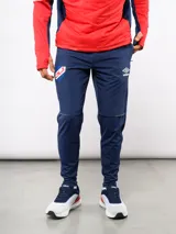 Pantalón de entrenamiento Umbro del Club Nacional de Football, color azul marino. Presenta un diseño técnico con paneles reforzados en la zona de las rodillas, escudo del club en el muslo derecho y logo de la marca en el izquierdo.
