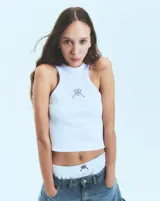 Musculosa blanca de morley con cuello redondo y sisas anchas. Isologo de la marca con tachas en el frente.