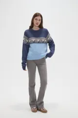 Sweater de tejido de punto con diseño jacquard, cuello redondo y mangas largas. Presenta una combinación de bloques de color azul marino y celeste con un patrón geométrico en la parte superior.