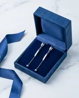 Caravanas colgantes de plata 925 con diseño minimalista compuesto por una pieza curva y una cadena fina terminada en una pequeña esfera.