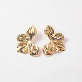 Caravanas de diseño floral con acabado metálico brillante en tono dorado.